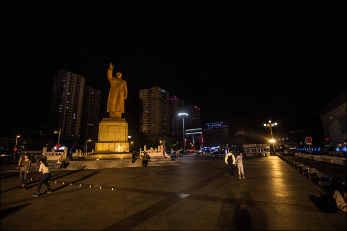 Mao Ce-tung szobra a dandongi pályaudvar előtti téren. A fénykép az érkezést követő másnap este készült, így ne legyen sekinek kételye afelől, hogy a pekingi járat esetleg éjszaka ér Dandongba.
