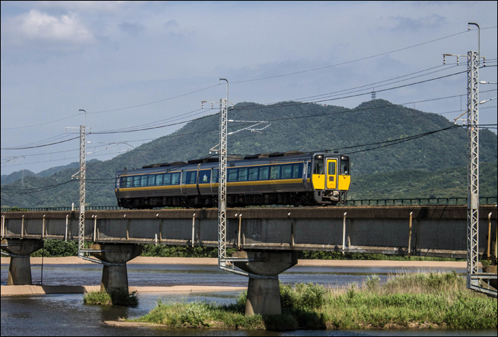 JR West 187-es sorozatú „Super Oki” gyorsvonat érkezik Izumoshi városába Tottori felől.