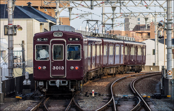 Hankyu 3000-es sorozatú motorvonat Hankyu – Itami (阪急伊丹) állomás közelében. A fekete háttérrel felszerelt viszonylatjelzőből egy pillantás alatt kiderül, hogy egy „Local”, tehát minden megállót érintő járatról van szó. A felvétel értékét tovább növeli, hogy nemcsak a képen látható motorvonat, de 2020. februárja óta az egész 3000-es sorozat eltűnt a Hankyu állományából, ami nem is csoda, hiszen 1964 és 1969 között készült járművekről van szó.