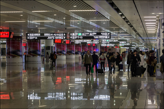 A Futian metró- és vasútállomás között húzódó aluljáró részlete, jobb oldalon vasúti menetjegyekért versenyző utasokkal.