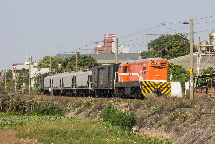 A tajvani TRA R20-as sorozatú dízelállata halad rövidke cementvonatával Dadu állomás közelében. Az EMD G12-es sorozatra alapozott, Tajvan számára 1960 és 1966 között készült járművekből összesen 52 volt megtalálható a vasúttársaság állományában, ezek végsebessége 100km/h, névleges teljesítménye 1060kW. Közeli országokban hasonló, ám A1A-A1A tengelyelrendezés helyett Bo-Bo (és 1067mm helyett 1435mm-es nyomtávú) változat található a Hongkongi Vasúti Múzeumban és egykoron Dél-Koreában is.