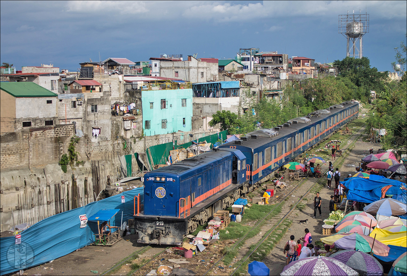 PNR 900-as sorozatú dízelmozdony halad vonatával Bicutan közelében. A PNR 1973 és 1991 között összesen 15 darab GE U14C és 6 darab, a képen is látható járműhöz hasonló GE U15C mozdonyt szerzett be, ám ezek többsége napjainkban már békésen rohad valahol.