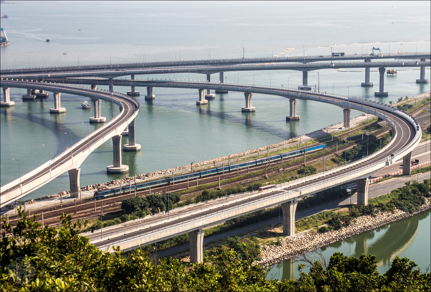 A hongkongi Airport Express egyik szerelvénye a Makaó és Zhuhai felé vezető grandiózus hídrendszer ki-/bejáratánál.