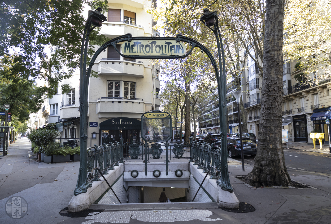 A párizsi metró Mirabeau megállójának 3-as számú bejárata. A korlátban helyet kapott, pajzsszerű objektumokban (hivatalos nevén escutcheonokban) a metrót szimbolizáló „M” betűt is megfigyelhetjük.