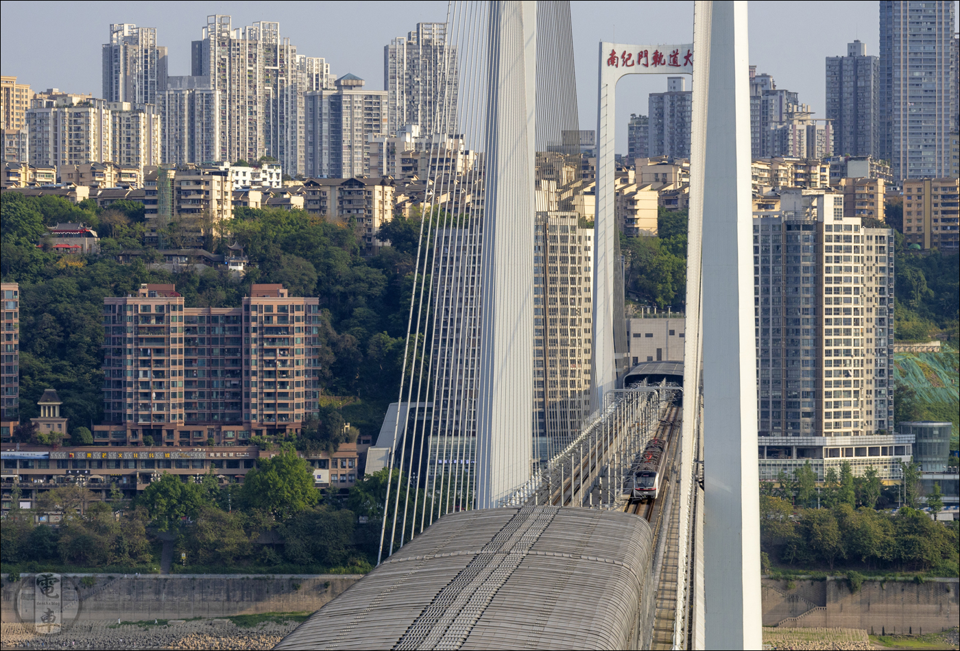 A Chongqing Rail Transit 10-es vonalán közlekedő egyik jármű Qixinggang és Houbao (ez utóbbi a távolban) megállók között a Jangce felett átívelő, 2023 januárjában elkészült, 1225 méter hosszú Nanjimen-hídon.