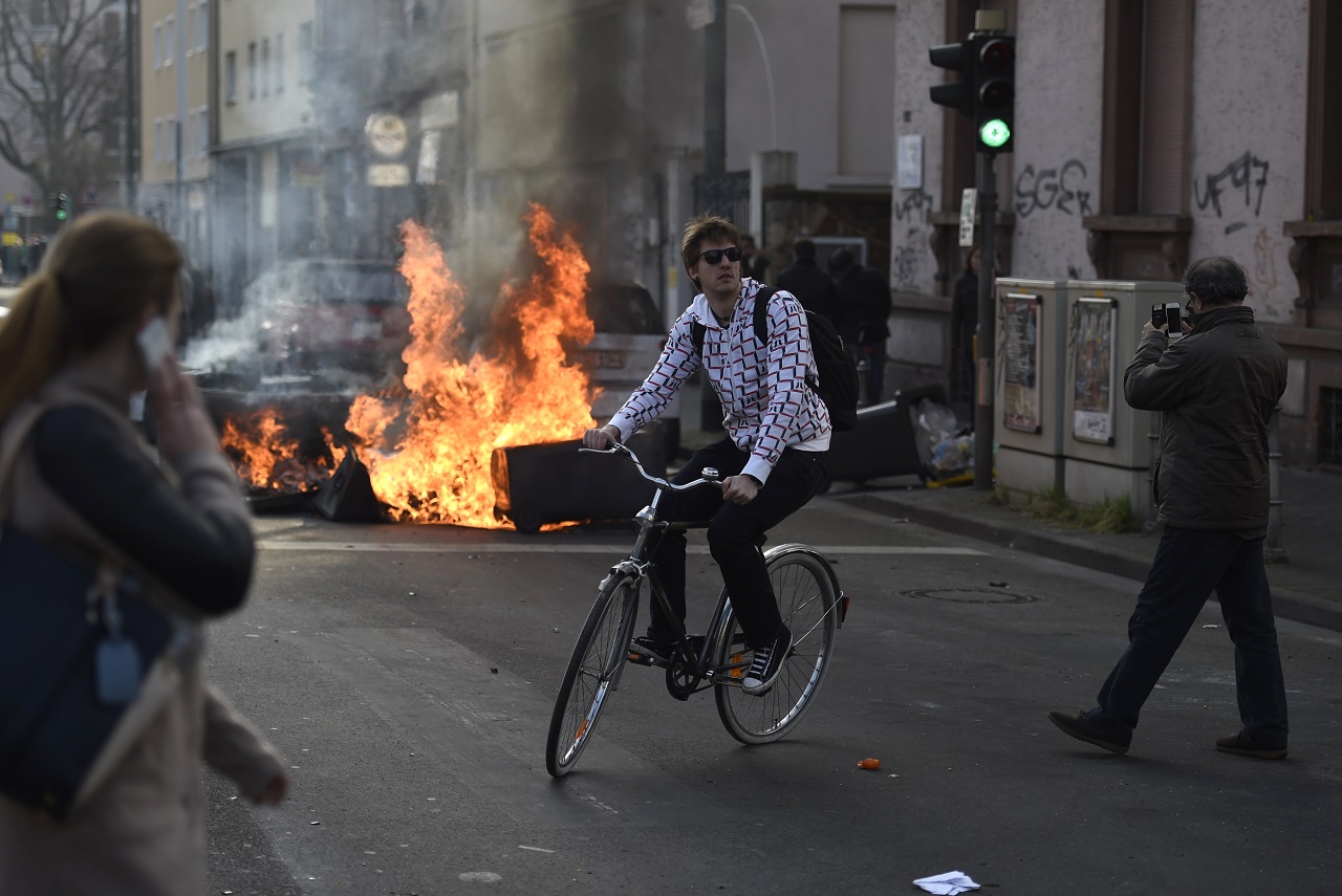 Biciklis férfi fordul inkább vissza a barikádtüzeket látva. A szervezők az Occupy mozgalmakkal való közösséget mutatva ‘Blockupy‘ névvel hívta utcára támogatóikat. (f.: Reuters)
