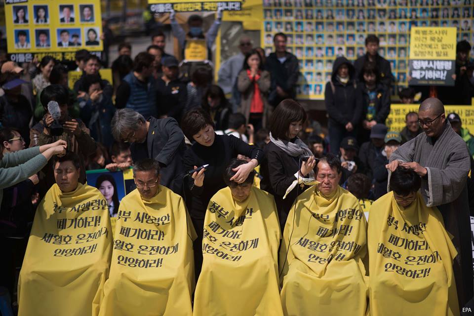 A tavaly ilyenkor történt koreai kompbaleset hallottainak 52 hozzátartozója borotváltatja le a fejét egy tiltakozás alkalmával, hogy ezzel is érvényt szerezzenek azon kívánalmuknak, hogy szigorú kivizsgálás történjen az ügy kapcsán. (f.: AFP)