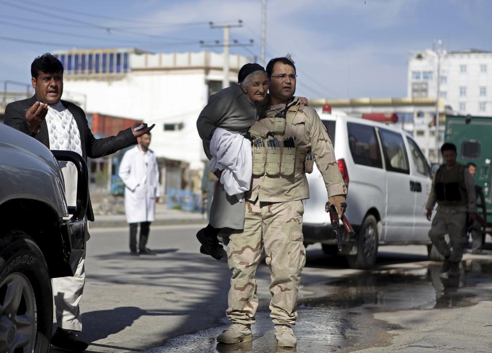 Az afgán fegyveres erők egyik tagja menekít ki egy idős nőt egy támadásból Mazar-i-Sharif-ban, Afganisztánban. (f.: AFP)