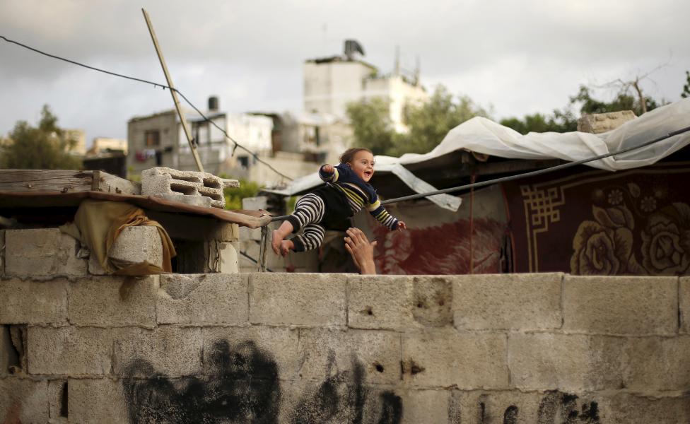 Egy palesztin gyereket dobálnak játékból a Gázai-övezetben található romos városnegyedben. (f.: Reuters)