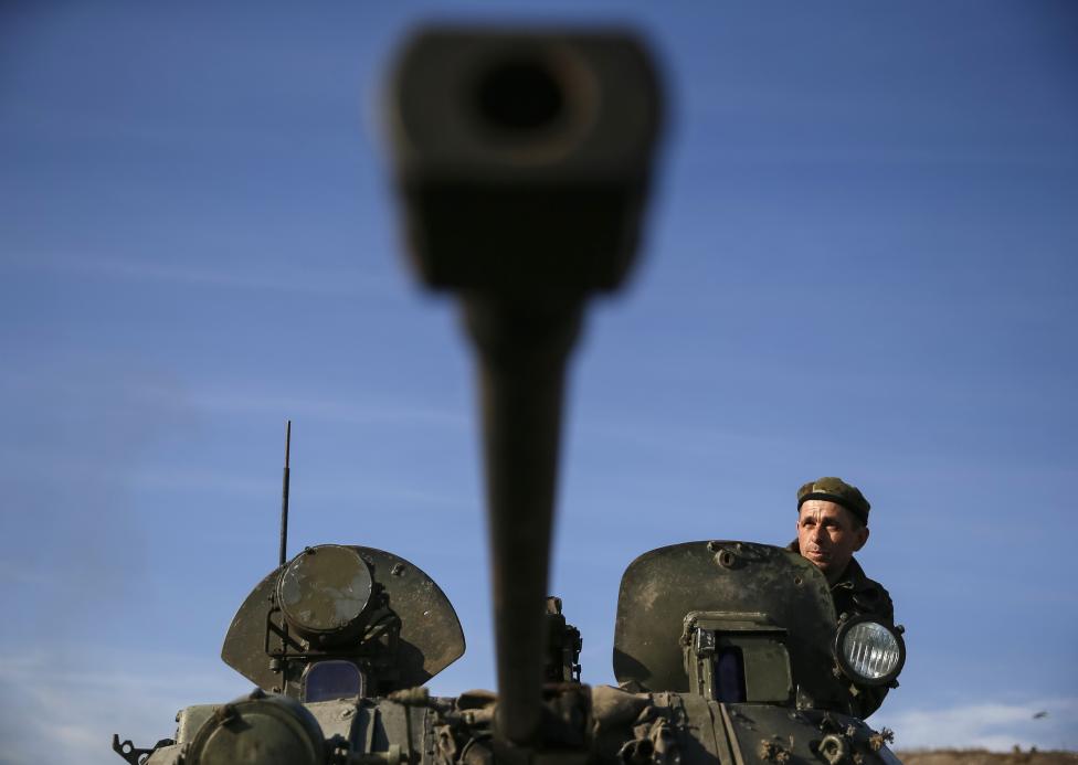 Ukrán katona szemléli a horizontot egy tank tetejéről Kurakovóban, Donyeck mellett (f.: Reuters)