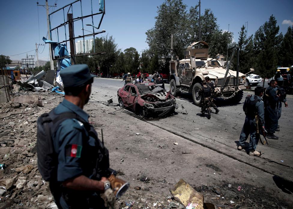 Egy afgán rendőr figyeli a június 30-i kabuli öngyilkos merénylet helyszínét. Legalább 17-en sérültek meg az afganisztáni fővárosban, mikor támadás ért egy NATO konvojt, amely épp áthaladt a város egyik fő utcáján. Ez a második nagyobb merénylet a helyszínen a Ramadán kezdete óta. (f.: Reuters)