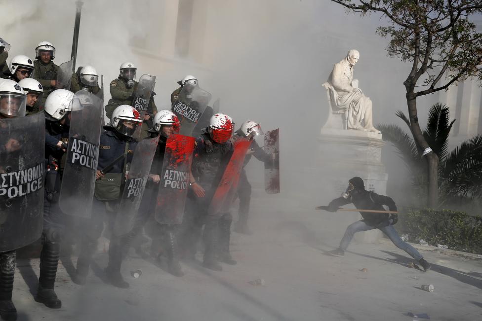 Tüntetők ütik botokkal és öntik le vörös festékkel a görög rohamrendőröket Athénban. A demonstráció résztvevői fel szerették volna hívni a figyelmet a szerintük túlságosan is szigorú antiterrorista törvényekre és a számos ezen jogszabályok által fogvatartott politikai fogolyra. (f.: Reuters)