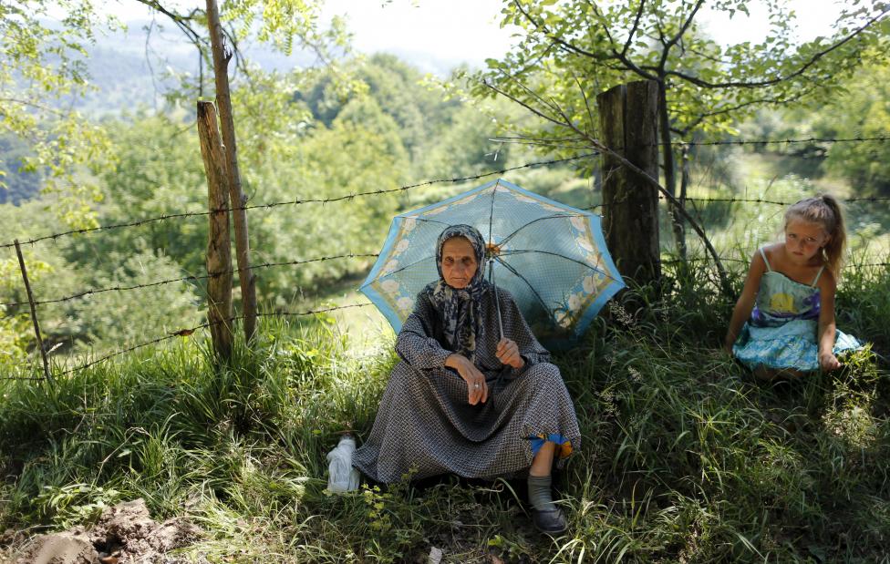 Egy idős hölgy figyeli a tömeget, amely a srebrenicai mészárlás 20. évfordulójára rendezett meneten vesznek részt. A résztvevők az ellenkező irányba járják végig azt az utat, amelyet a szerb csapatok elől Srebrenicából Tuzlába menekülő lakosság járt be egykor. (f.: Reuters)