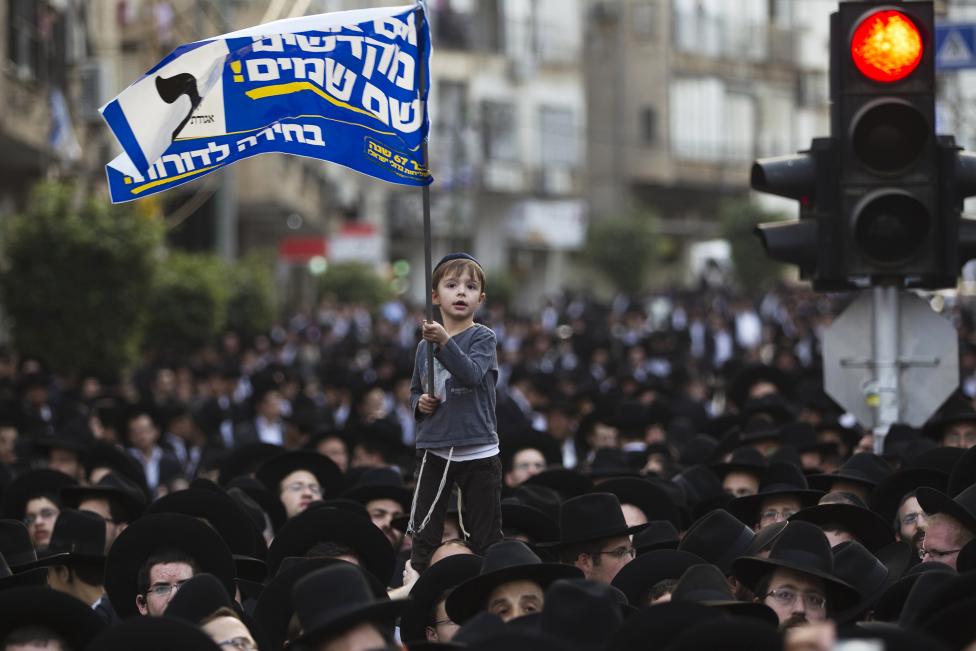 Fiatal izraeli fiú lengeti a zászlót egy, az Egyesült Tóra Judaizmus orotodox párt által szervezett politikai rendezvényén Tel-Aviv mellett. (f.: Reuters)