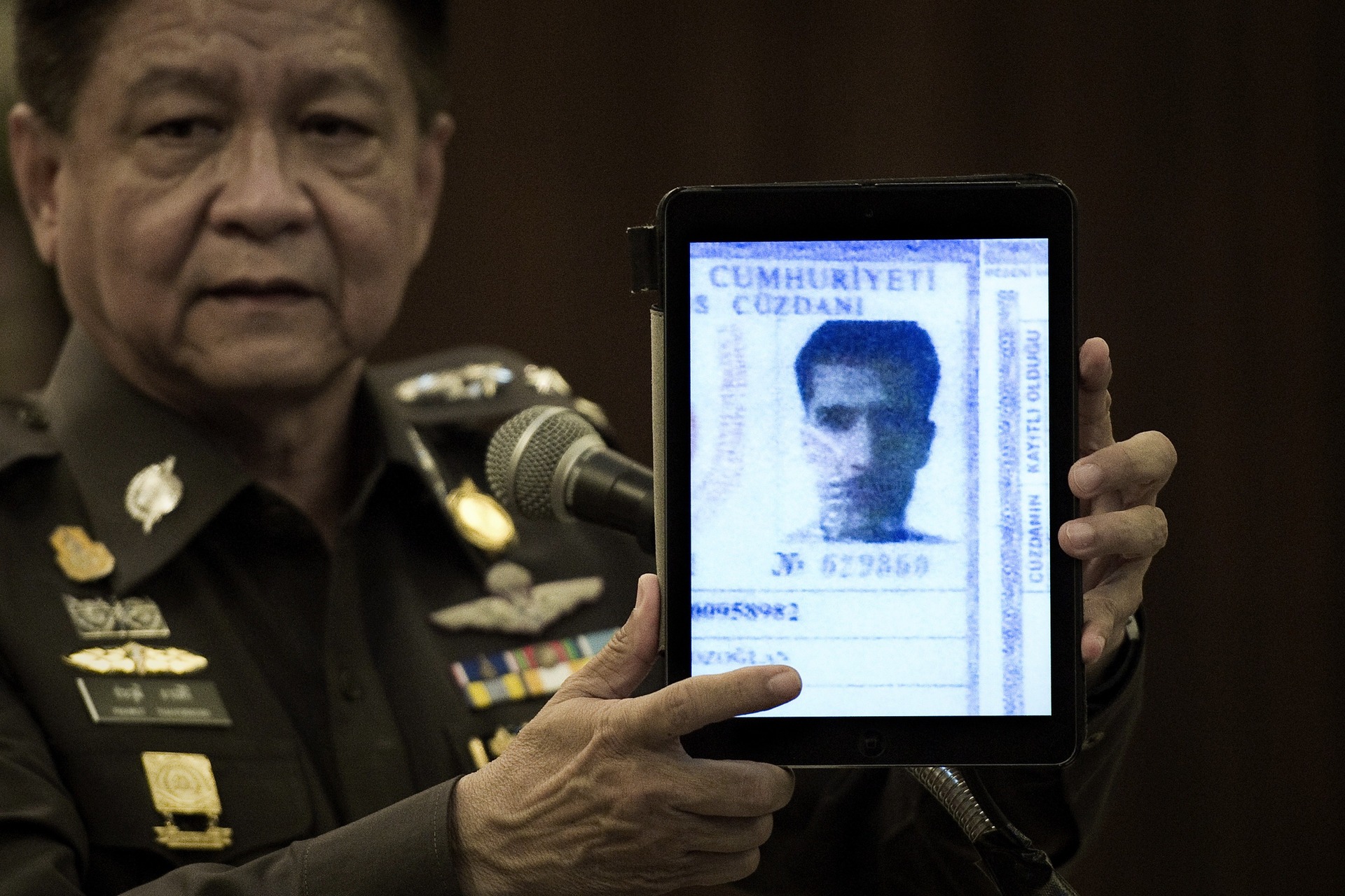 Prawut Thavornsiri, a thai rendőrség szóvivője tartja fel  Ahmet Bozaglan, egy külföldi férfi fényképét, akit (többek mellett) jelenleg gyanúsítanak a múlt havi bangkoki robbantással. (f.: AFP)