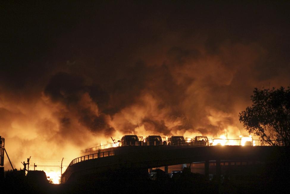 Gépkocsik lángolnak a Tiencsinben, Kínában lévő vegyiüzem raktár robbanása után. Az esetnek eddigi információk szerint legalább 50 halálos áldozata és közel 500 sebesültje van. (f.: Reuters)