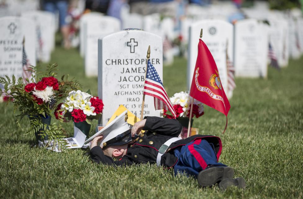 A 4 éves Christian Jacobs díszegyenruhában fekszik apja, Christian James Jacobs sírján az Arlingtoni Nemzeti Temetőben, a május 25-én rendezett Memorial Day napján - amikor az Egyesült Államokban azoka a honfitársaikra emlékeznek, akik katonai szolgálat során vesztették életüket. (f.: Reuters)  