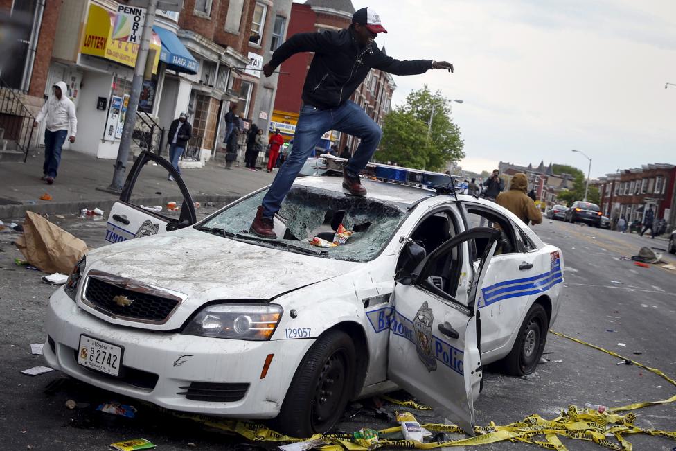 Egy tüntető ugrál a totálkáros rendőrautón Baltimore utcáin. Az Egyesült Államokban újabb nagy erejű tüntetések indultak a fekete lakosság ellen elkövetett rendőrségi jogtalanságok miatt. A helyzet elmérgesedése miatt Baltimore-ba még a Nemzeti Gárdát is kivezényelték. (f.: Reuters)