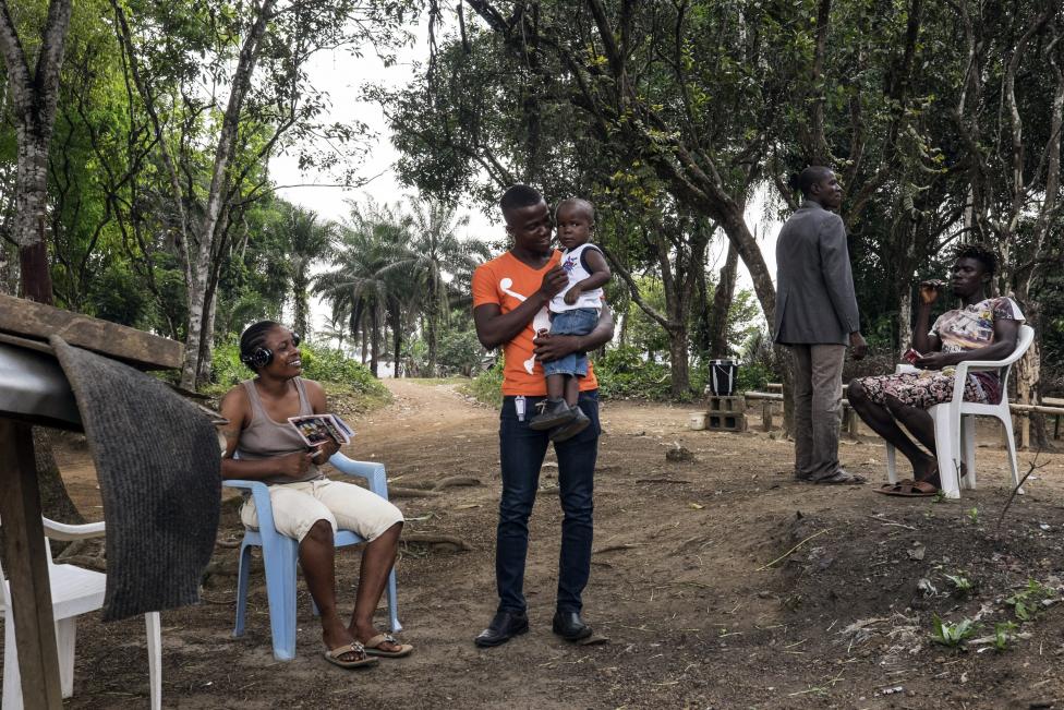Egy ebolát túlélő férfi tartja első alkalommal a karjaiban gyermekét Libériában, miután véget ért számára a több hónapos karantén megfigyelés időszaka (f.: Reuters)