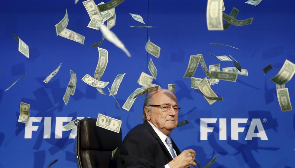 Sepp Blatter FIFA elnököt dobálják meg bankjegyekkel, utalva az őt és az általa vezetett szervezett körüli korrupciós botrányokra. (f.: Reuters)