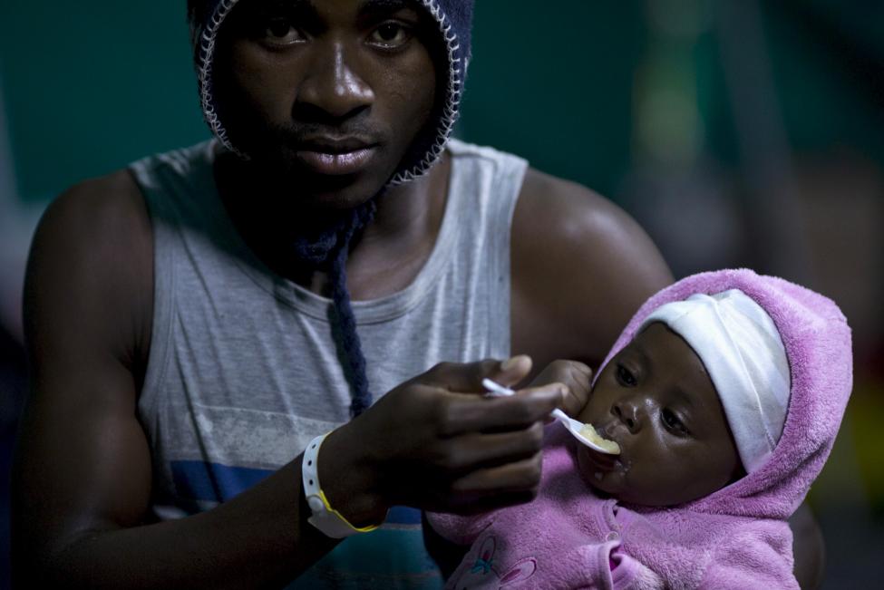 Egy külföldi férfi etet egy gyermeket Isipingo-ban, Dél-Afrikában. Több száz külföldinek kellett elhagynia otthonát és sátorokból épített menekülttáborokba húzódnia, miután az országban fellángoltak az idegenellenes erőszakos megmozdulások. (f.: Reuters)
