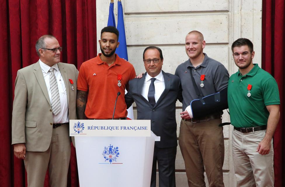 François Hollande áll azon férfiak gyűrűjében, akik megakadályozták a múlt pénteki terrortámadást egy Párizs felé tartó vonaton. Hollande a legmagasabb  rangú kitüntetést, a Becsületrendet adta át Chris Norman brit üzletembernek (balra), U.S. student Anthony Sadler amerikai diáknak (második balról), Spencer Stone (jobbról a második) és Alek Skarlatos (jobbra) amerikai tengerészgyalogosoknak. (f.: Reuters)
