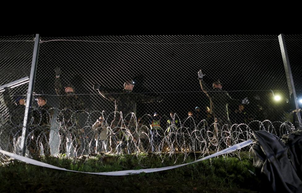 Ez azonban október 17-re (szombatra) virradóan megváltozni látszik, mivel a magyar kormány döntött az itteni határzár felállításáról is. A képen magyar honvédek építik a kerítést Botovo környékén. (f.: Reuters)