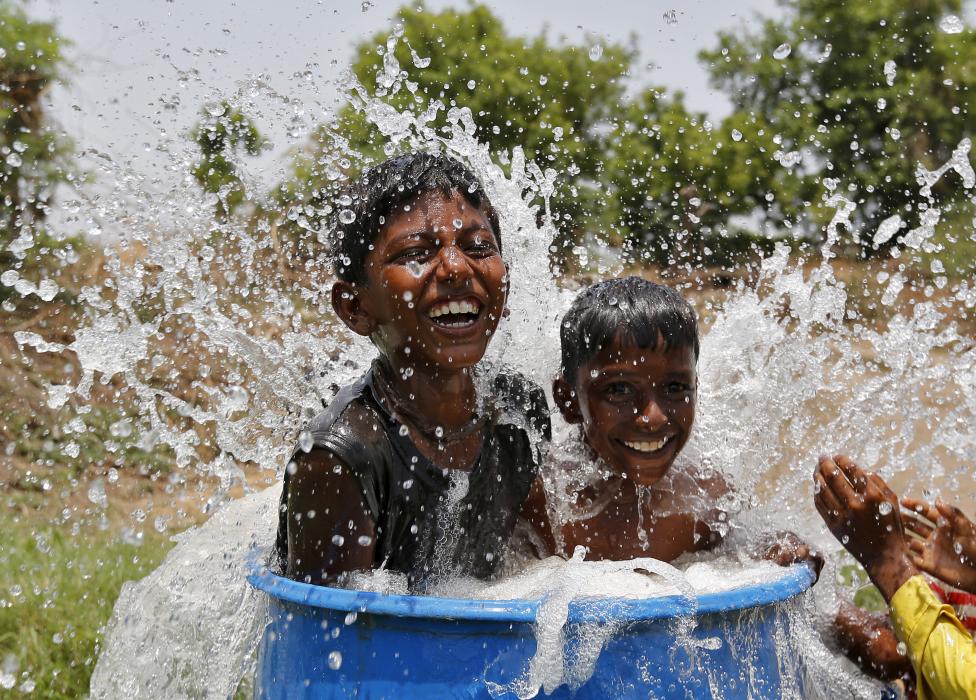 Indiai gyerekek hűtik magukat egy vízzel teli hordóban. Az országban a hét folyamán több mint 1370-en vesztették életüket a rekord magas, 47 Celsius fokos hőhullám miatt. (f.: Reuters)