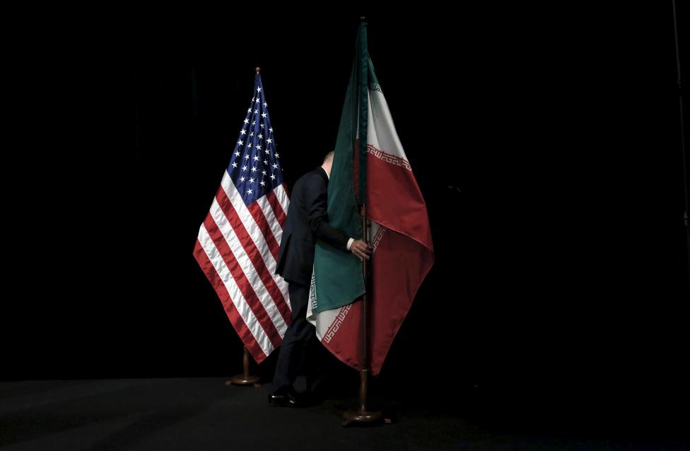 Egy szervező kezdi elpakolni az iráni és amerikai zászlókat, miután végeztek a sajtótájékoztató során készült csoportképekkel. Kedden sikerült pontot tenni a 13 éves iráni atomvitára, aminek értelmében Irán többek között beleegyezik a dúsított uránmennyiségének drasztikus csökkentésébe és a nukleáris létesítmények nemzetközi ellenőrzés alá helyezésébe. (f.: Reuters)