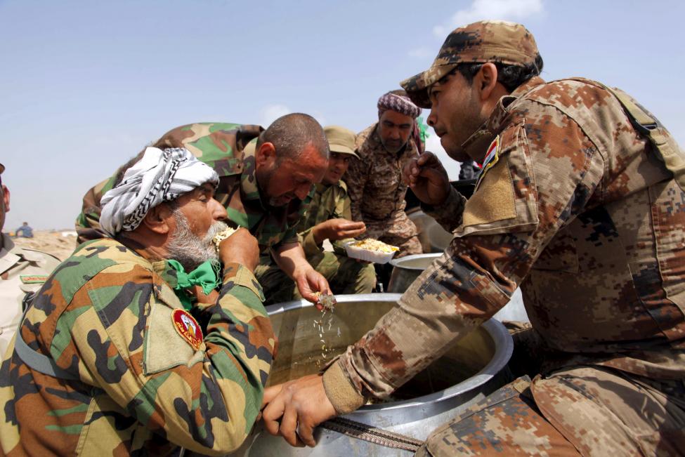 Iraki milicisták étkeznek Tikrit külvárosában, miután sikerült felülkerekedni az Iszlám Államon (f.: Reuters)