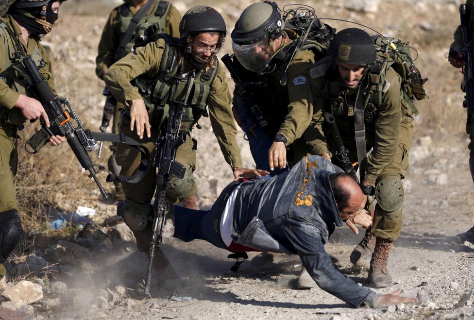 Izraeli katonák vesznek őrizetbe egy palesztin férfit, aki részese volt a Gázai-övezetben a zsidó telepek létrejötte ellen szervezett tüntetésnek. (f.: Reuters)