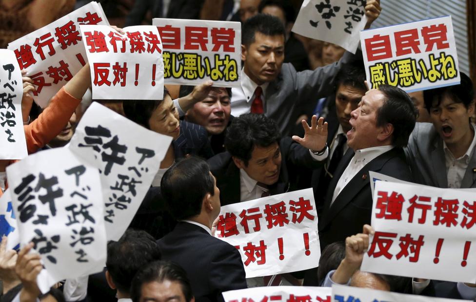 Hamada Jaszukazu-t, a japán felsőház védelmi bizottságának elnöke próbálja túlordítani az őt körülvevő ellenzéki politikusok hadát, akik a békealkotmány reformja ellen tüntetnek. Az alsóház már elfogadta a módosításokat, amivel Japán engedélyezné, hogy katonái külföldön is bevethetőek legyenek különböző közös missziókban (amire a második világháború óta nem volt példa). A japán társadalom többsége jelenleg nem támogatja a lépést. (f.: Reuters) 