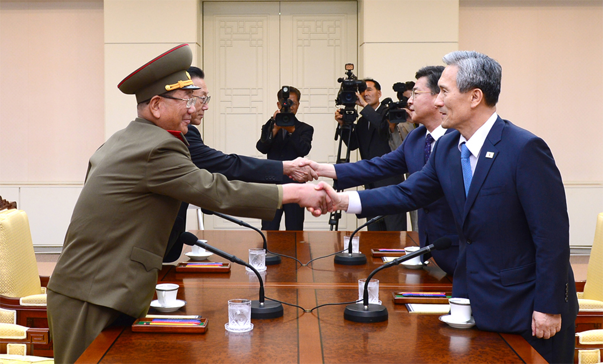 Észak- és dél-koreai vezetők fognak kezet a demilitarizált zóna egyik falujában tartott béketárgyaláson, amelyen sikerült megegyezni a két állam háborús készületi szintjének csökkentéséről. A közös nyilatkozat értelmében Phenjan bocsánatot kér az augusztusi incidens miatt, amelyben két déli katona halt meg az elméletileg demilitarizált zónába telepített gyalogsági akna miatt, Szöul pedig leállítja az északi területeket célzó propaganda tevékenységét. (AFP PHOTO / The South Korean Unification Ministry)