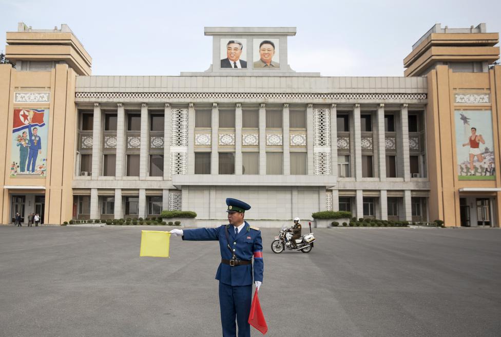 Rendőr irányítja a forgalmat az észak-koreai Kim Il Sung stadion előtt. (f.: Reuters)
