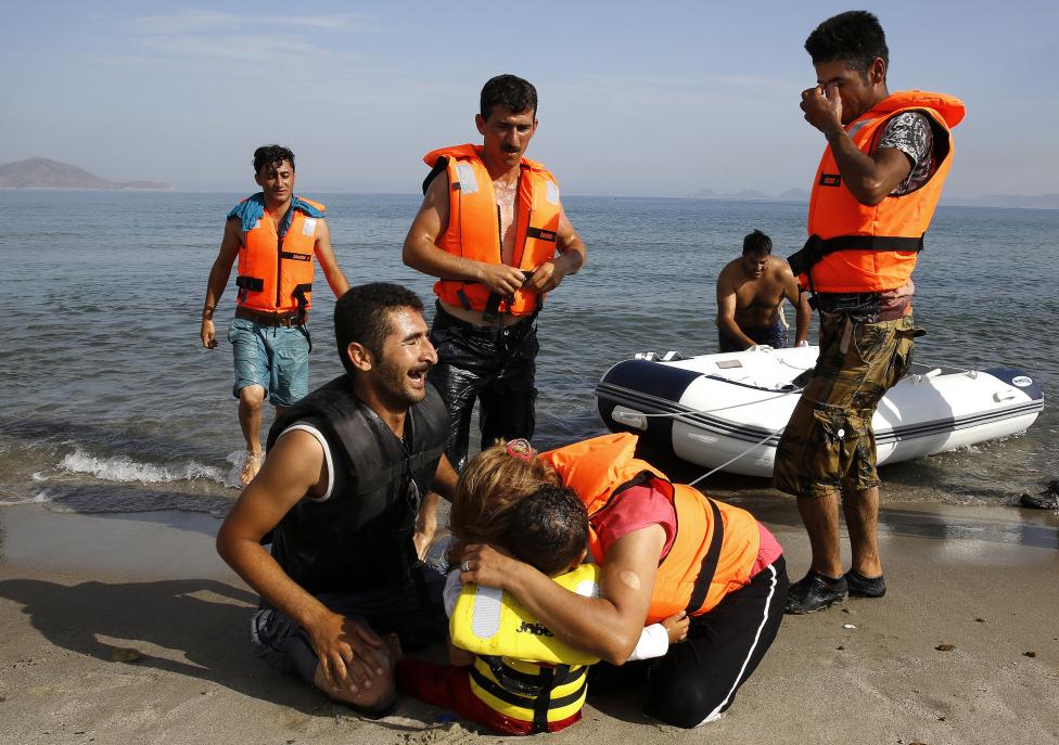 Iráni menekültek sírnak, miután Törökországból áteveztek motor nélküli csónakjukkal, és partot értek Kos szigetén. (F.: Reuters)