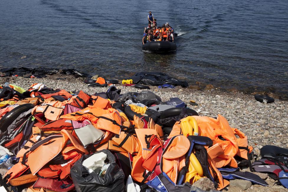Bevándorlók érkeznek egy kis csónakban a görögországi Leszbosz szigetének partjához, ahol a korábban érkezők már eldobálták mentőmellényeiket. (f.: Reuters)
