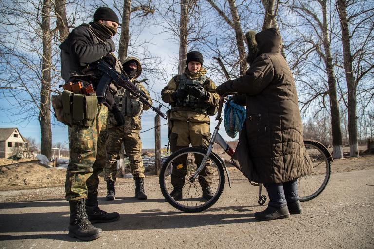 Katonák ellenőrzik egy biciklis helyi lakos papírjait Luganszk megyében (f.: Reuters)