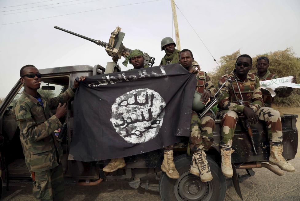 Nigériai katonák emelik magasba a fotó kedvéért a Boko Haram zászlóját, amit nemrég szereztek meg a terroristáktól, mikor visszafoglalták Damaszk városát. (f.: Reuters)