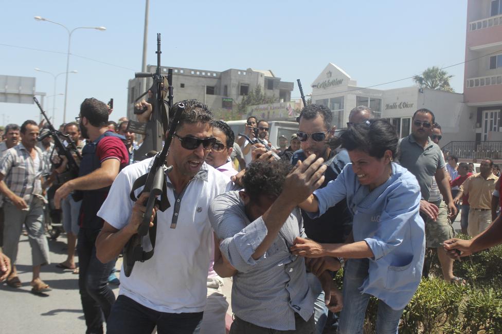 Tunéziai rendőrtisztek vezetnek el a dühös tömegből egy embert, akinek feltételezhetően köze volt a pénteken végrehajtott terrortámadáshoz. A gumicsónakkal a strandra érkező fegyveresek 38 embert öltek meg, az áldozatok túlnyomó része turista volt. Az ISIS magára vállalta a támadást, azonban ennek hitelessége jelenleg még nem bizonyított. (f.: Reuters)