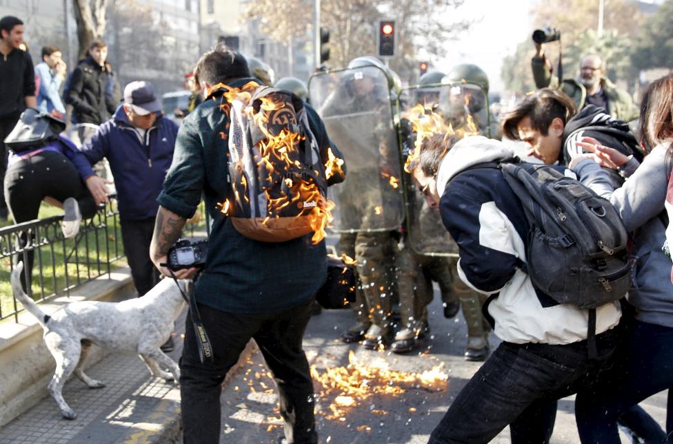 Tüntetők lángolnak, miután őket is elérte egy molotov-koktél által okozta robbanás. A chilei Santiago belvárosában hetek óta tüntetnek tanárok és diákok az oktatási rendszer reformjai érdekében. (f.: Reuters)