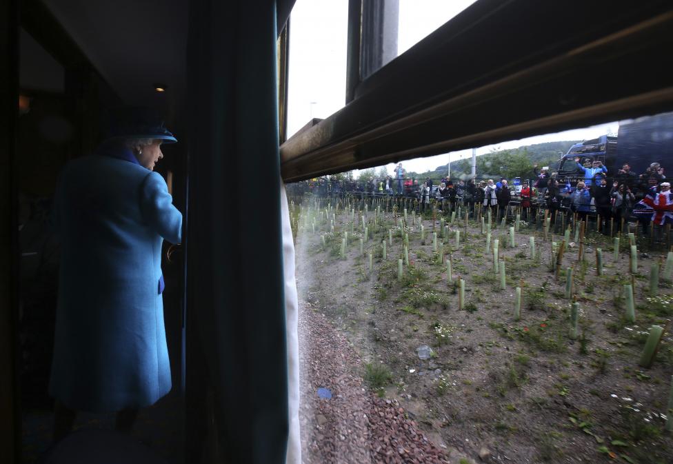 II. Erzsébet királynő tekint ki vonatkocsijából az út mellett álló tömegre, miközben az Scottish Borders Vonattársaság által lefedett új, most megnyitott útvonalon utazik. Szeptember 9. óta II. Erzsébet a brit korona leghosszabban uralkodó tagja, ezzel maga mögé utasította az eddigi ‘csúcstartót‘, a több mint 63 és fél évig a trónon ülő Viktória királynőt is. (f.: Reuters)