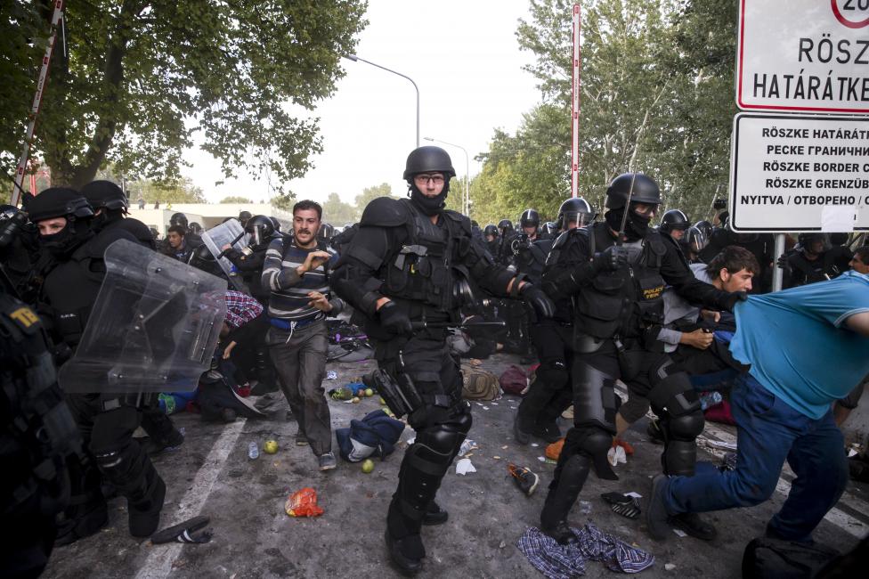 Magyar rohamrendőrök próbálják szétverni a magyar-szerb határon húzott határzárat megbontani akaró menekültek csoportját Röszkénél. (f.: Reuters)