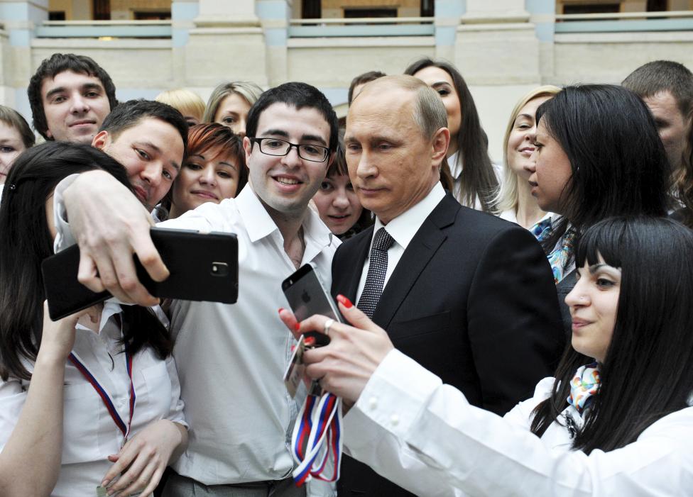 Vlagyimir Putyin áll pózban egy selfie-hez a betelefonálós műsor technikai munkatársaival. (f.: Reuters)