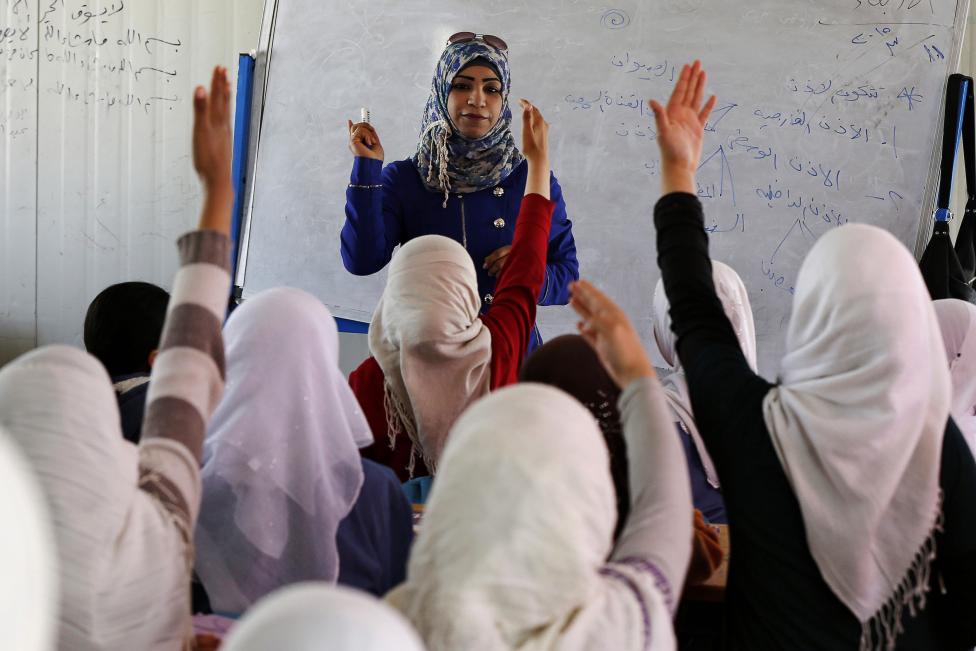 Lányok jelentkeznek egy szíriai menekülttáborban felépített ideiglenes iskolában (f.: Reuters)