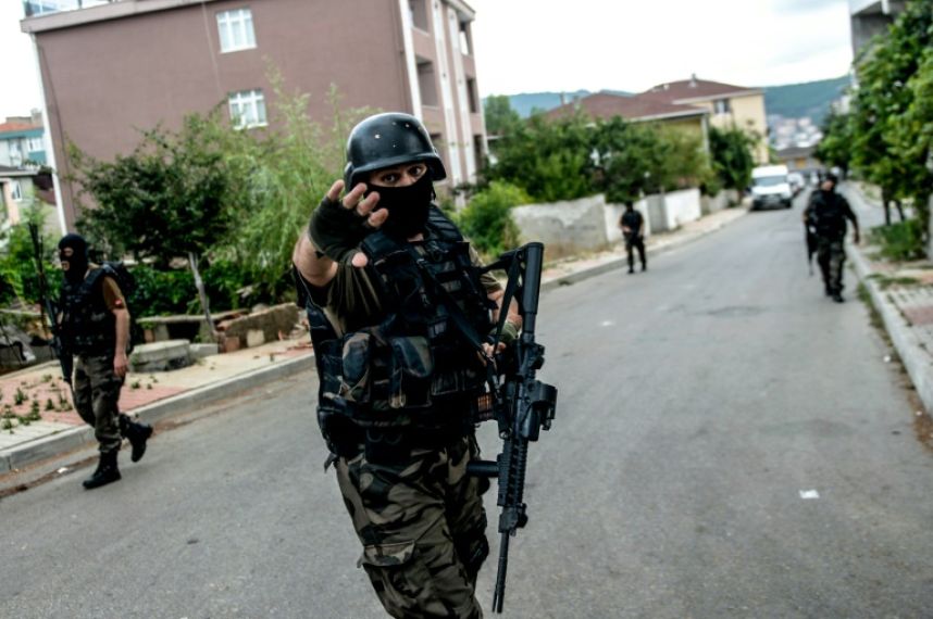 A török rendőrség különleges alakulatának egy tagja inti távolmaradásra a fotóst. Isztambulban két összecsapás is történt augusztus 10-én, hétfőn, amikor fegyveresek támadták meg a helyi amerikai nagykövetséget és egy rendőrkapitányságot is. (f.: AFP)