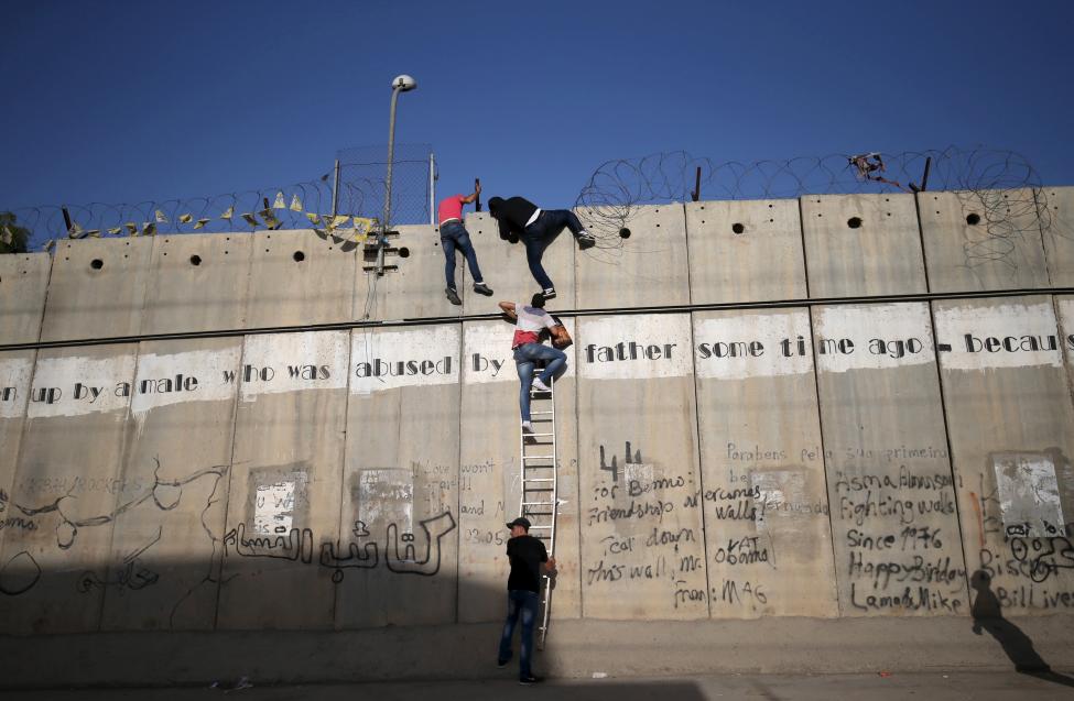 Palesztinok másznak át a Jeruzsálem és a Gázai-övezet között emelt falon, hogy részt vegyenek a ramadáni ünnepségeken és imákon. (f.: Reuters)