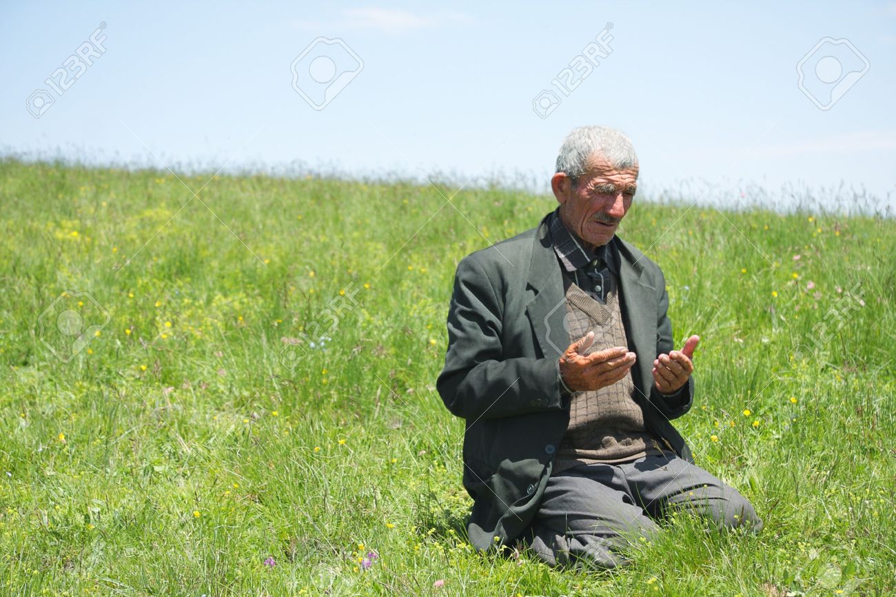 7625599-senior-uomo-sollevamento-mani-in-preghiera-sulla-collina-erbosa--archivio-fotografico.jpg