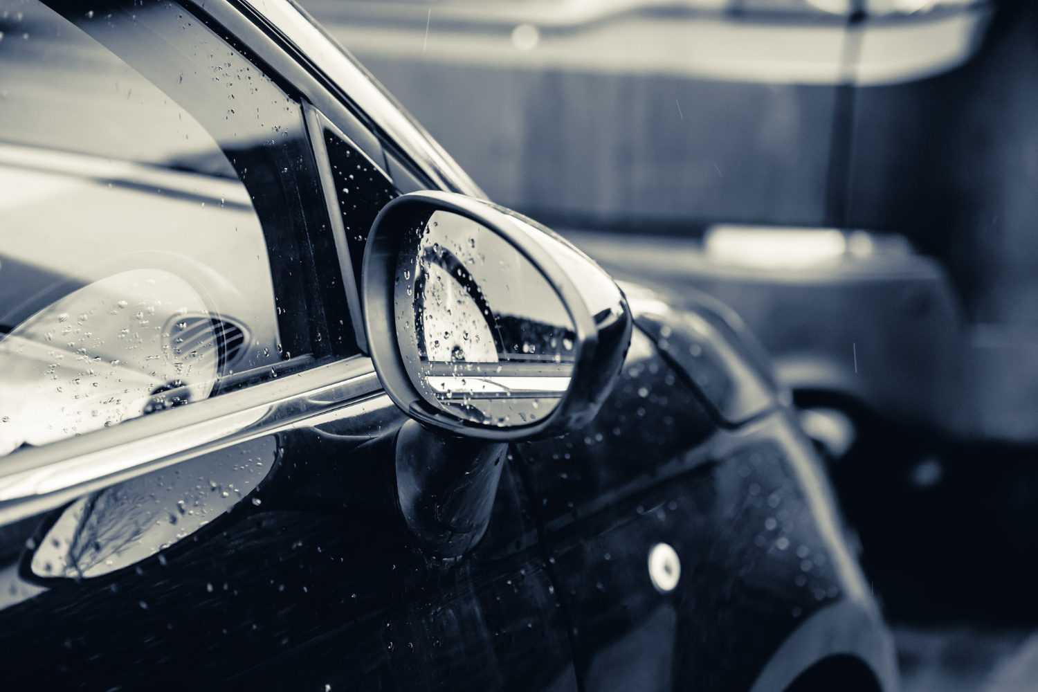closeup-rearview-mirror-black-car-covered-raindrops.jpeg