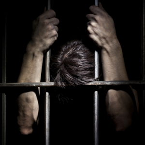 male-prisoner-holding-bars-300.jpg