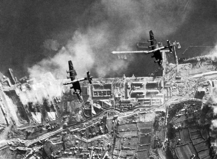 Halifax bombázók Brest felett. A dokkban álló, részben füsttel borított csatacirkálók a kép bal oldalán láthatók.